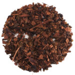 Loose leaf Honeybush herbal tea with reddish-brown color on a white background